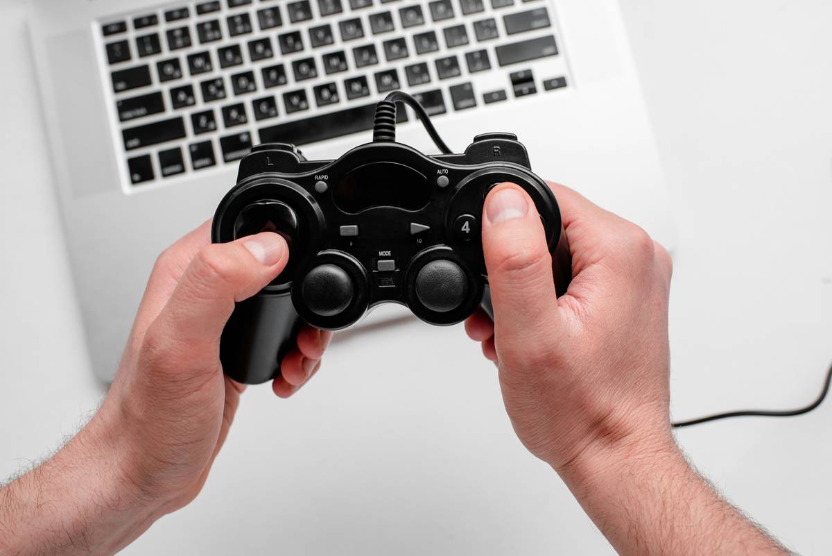 game programming development beginning c through: student writing C++ console game code on laptop